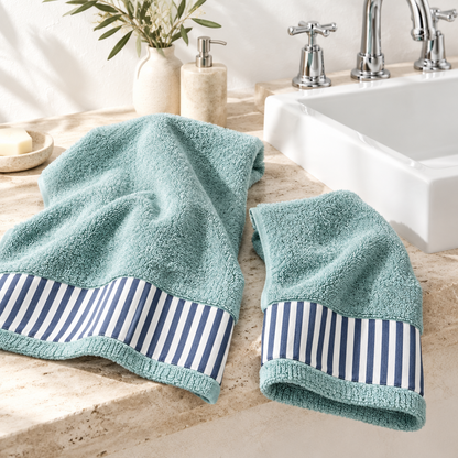 Set asciugamani bagno viso e ospite in spugna di cotone verde acqua con bordo a righe blu e bianche in ambiente